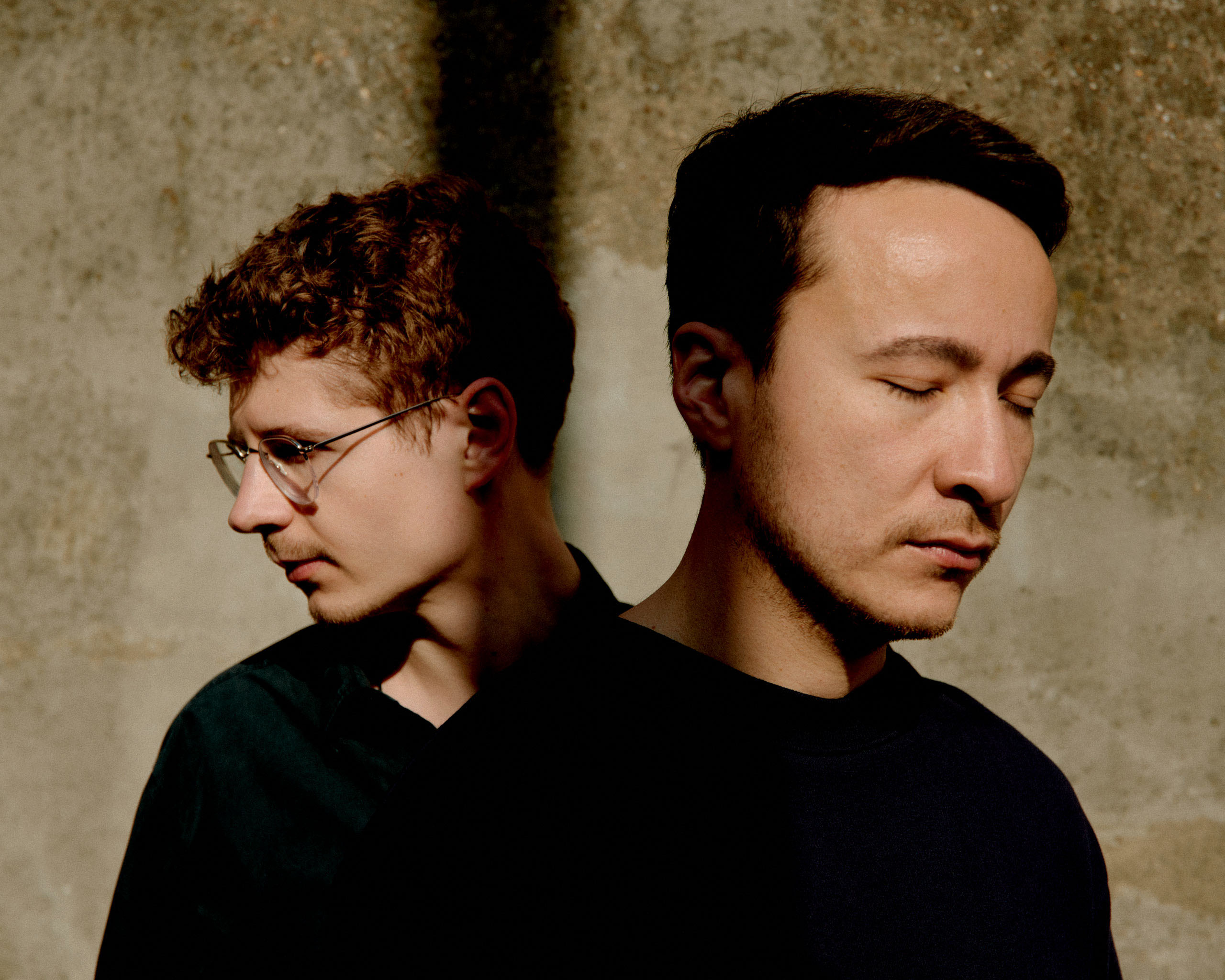 Pavel Kolesnikov en Samson Tsoy naast elkaar voor een muur.